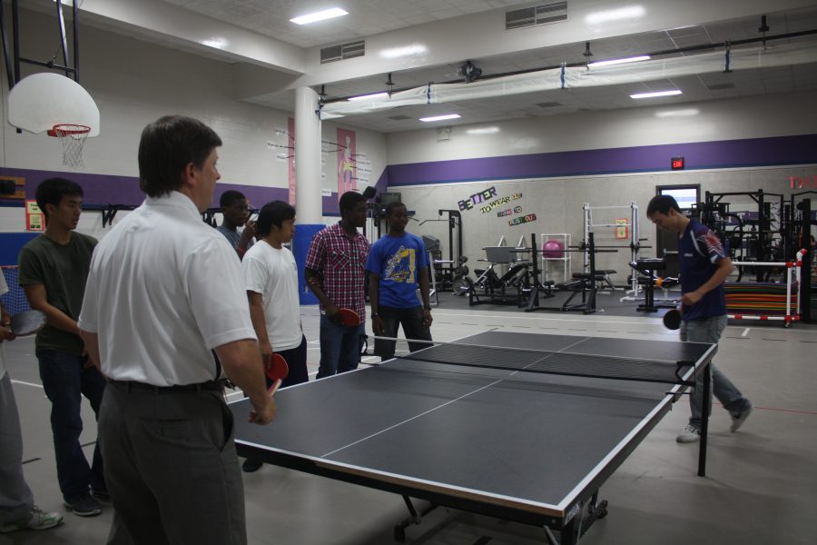 Timothy Wang playing a game of table tennis with superintendent H.D Chambers