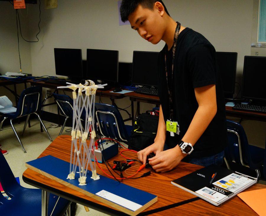 Freshman Linh Nguyen tests out his elevator mechanism by varying weight, speed, and time in a project this fall.