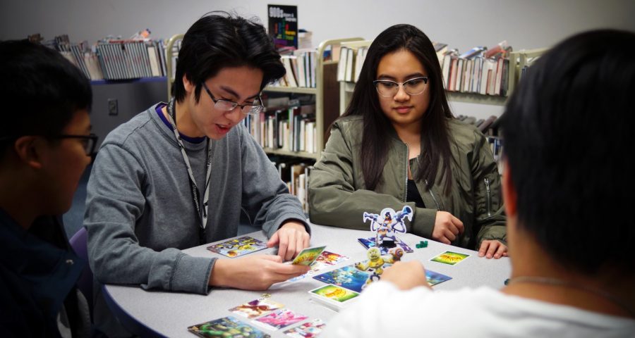 Seniors Nam Dang and Liezl Faith Canlas enjoy a game of King of Tokyo with their friends. 