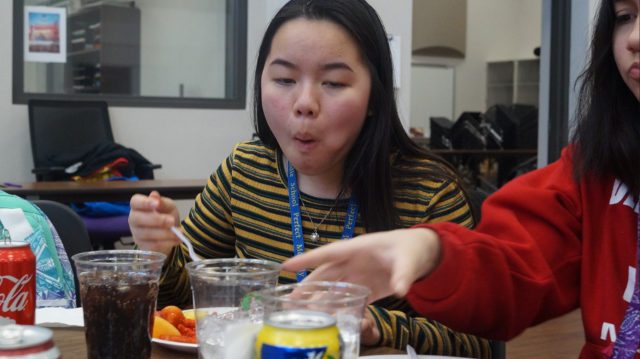 My Tran eats food during the Orchestra Christmas party.