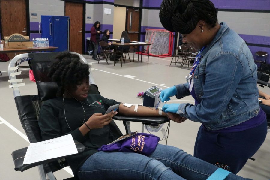 Henrietta Cole, the Gulf Coast Regional Blood Center phlebotomist, is drawing blood from Dominique Carter on September 2.