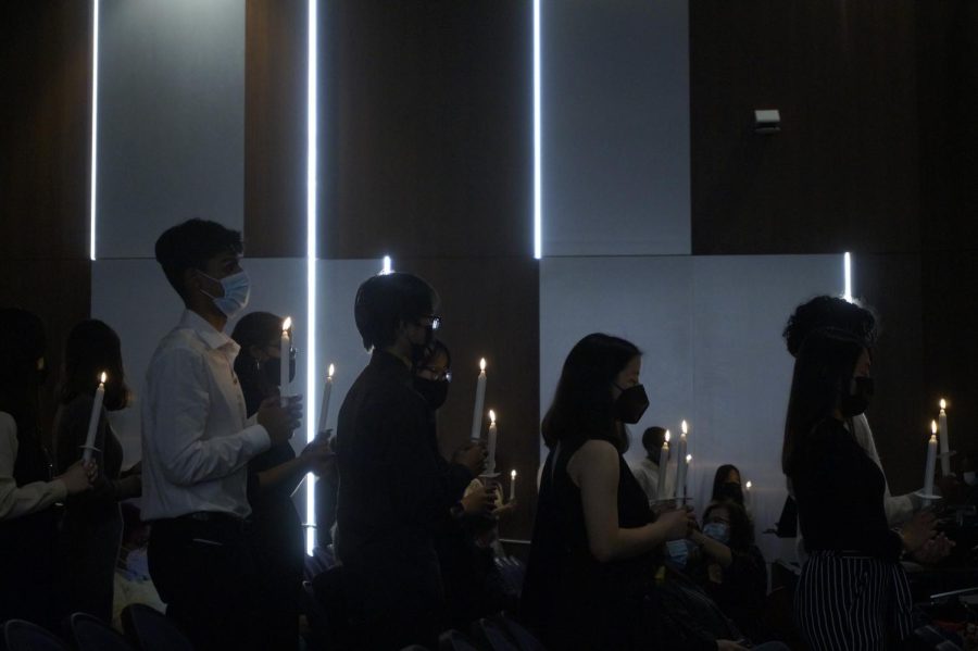 New members hold on to their lightened candles as the induction takes place.