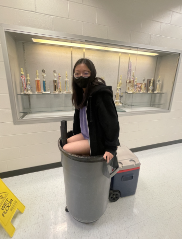 Treasurer, Daniella Do, jumps into the trashcan so that she can push down the trash that they cleaned out of the STUCO closet. 