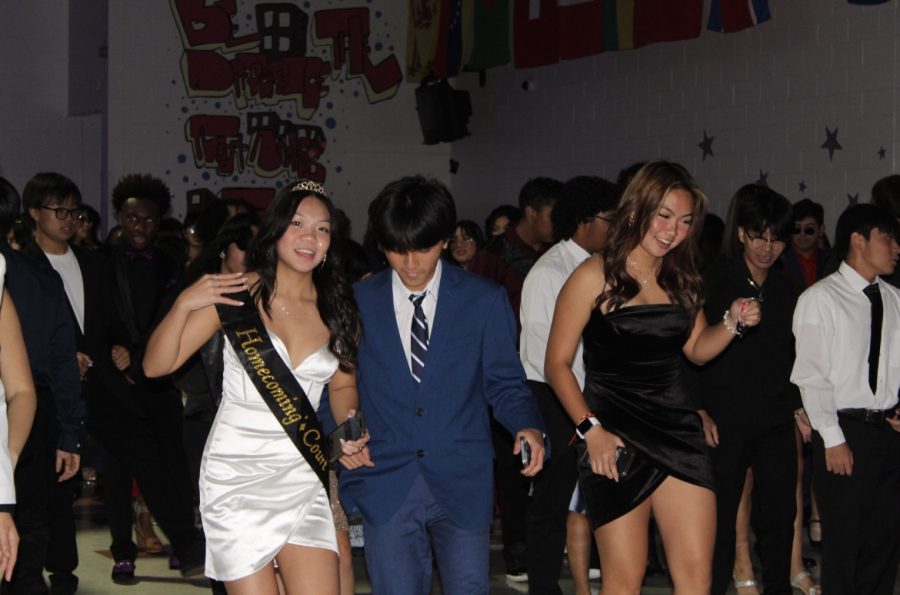 In a line, Mia Nguyen, Taylor Nguyen, and Vivian Le dance to the Cupid Shuffle. 