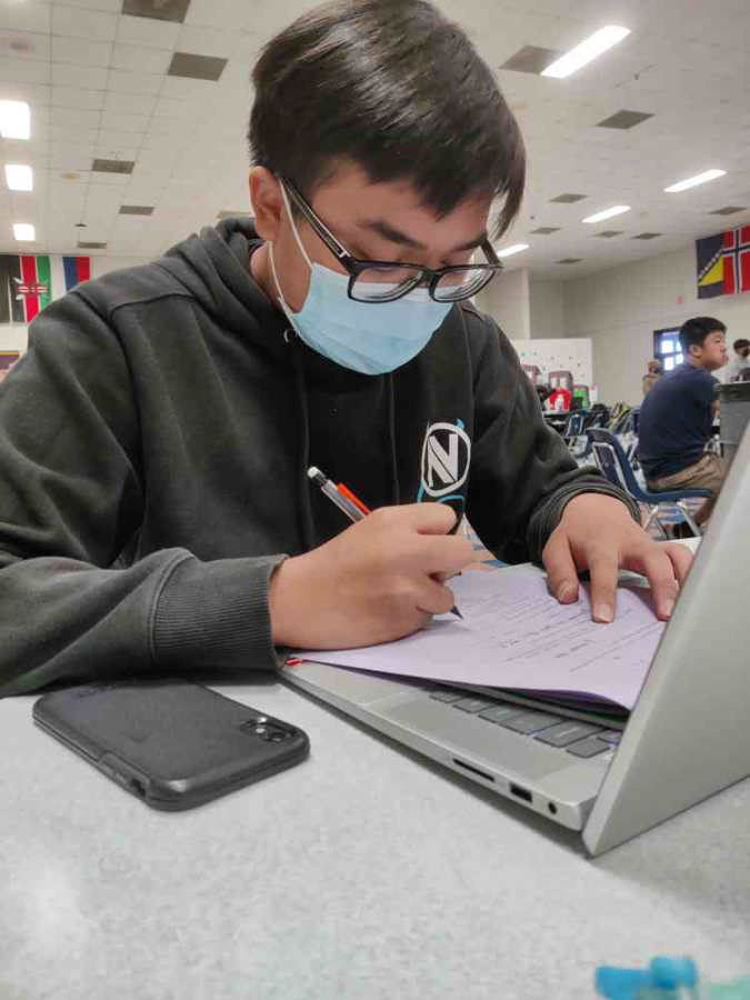 Platini Nguyen works on his Calculus work in the cafeteria.