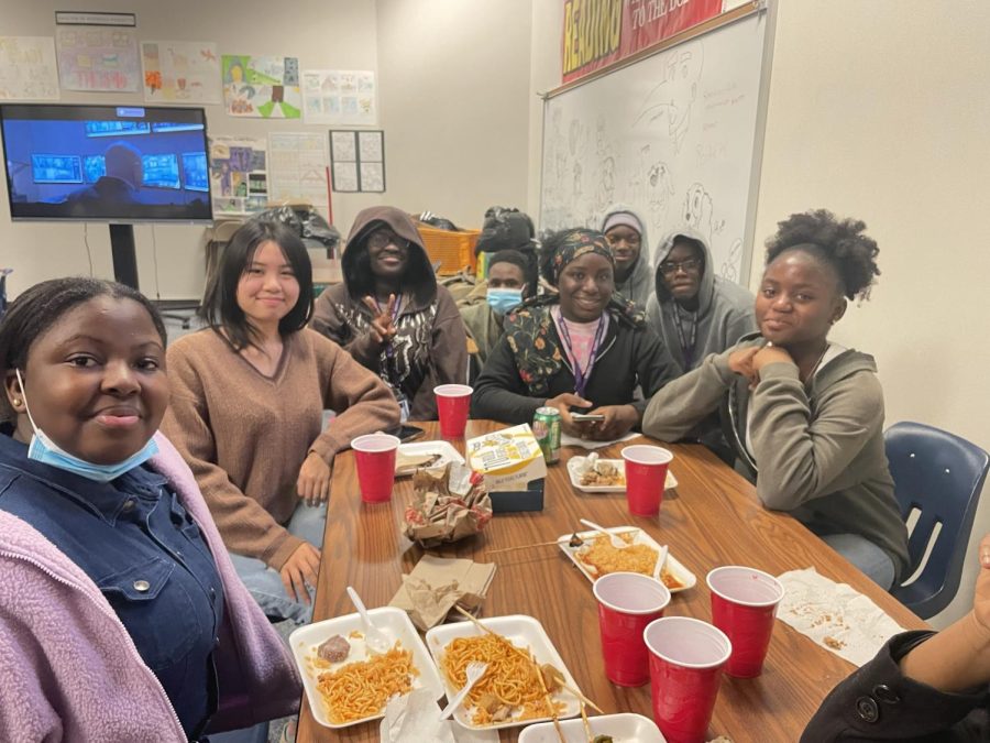TSC members eating food and watching Black Panther at the holiday potluck.