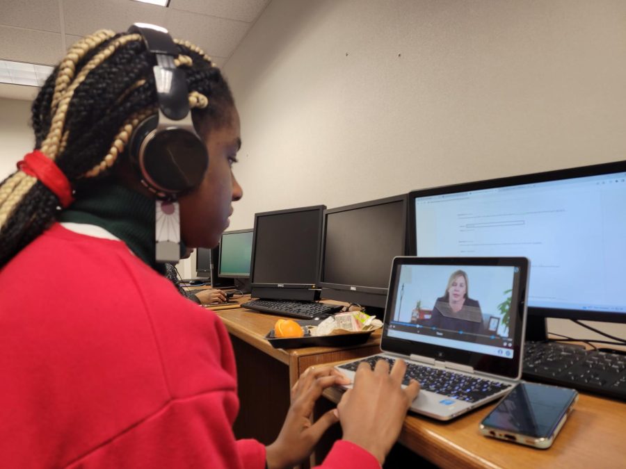 Clare Nneji listens to an educational video regarding business management. 