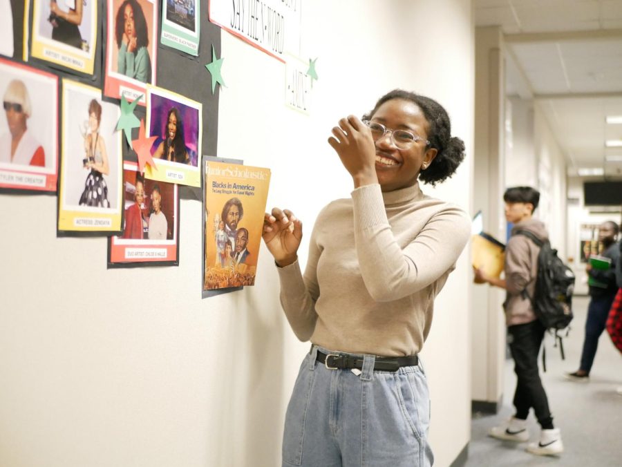 Azeezat Akinboro reads the information pamphlets displayed on the Black History Month Wall. 