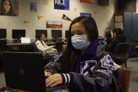 Natalie Nguyen, a former band member, happily wears her new letterman jacket while doing work. 