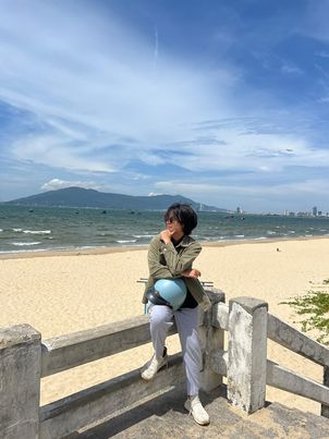 Khue posing for a photo in a tourist attraction during their vacation to Vietnam.