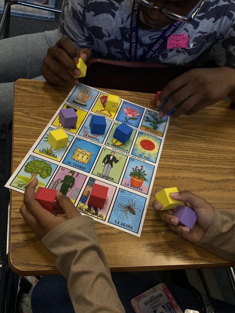 Students at the Latinx club interest meeting enoying a
game of The Mexican Bingo, Loteria. At the top, Isaiah
Goubert pays attention to where he wants to place his color
block.