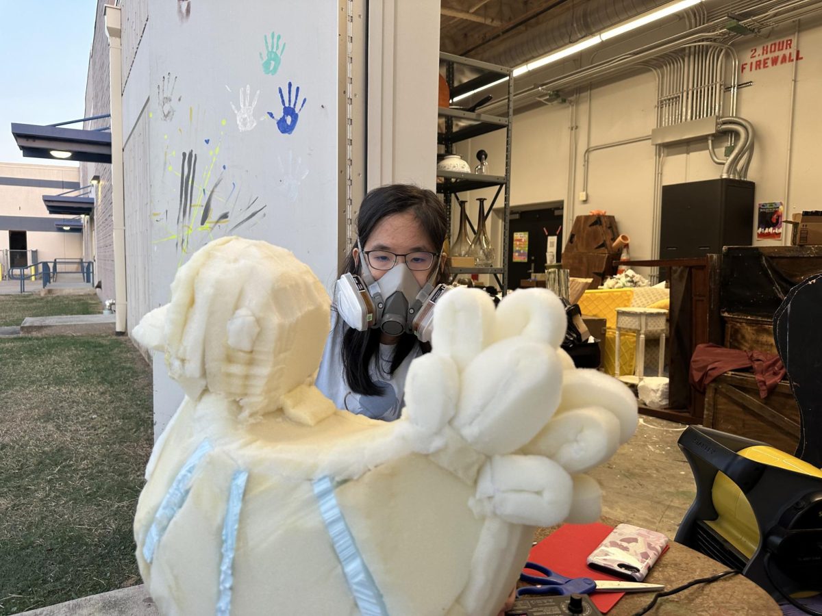 Senior Lillian Tan builds a chicken prop for the upcoming Cadre production. 