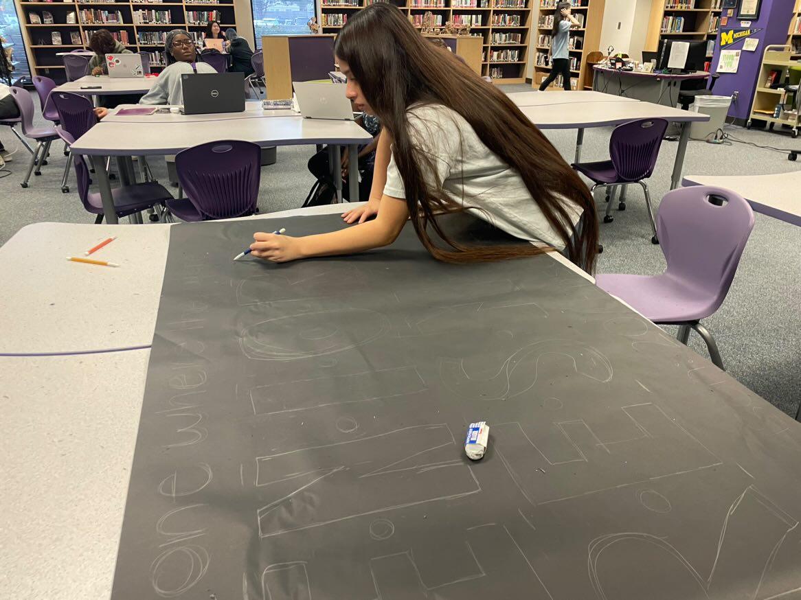 Posting Spirit. Class vice-president Kaylee Toruno traces letters on banner. She enjoyed working with her fellow officers in the library as they created the poster. We are trying to work quickly, said Toruno