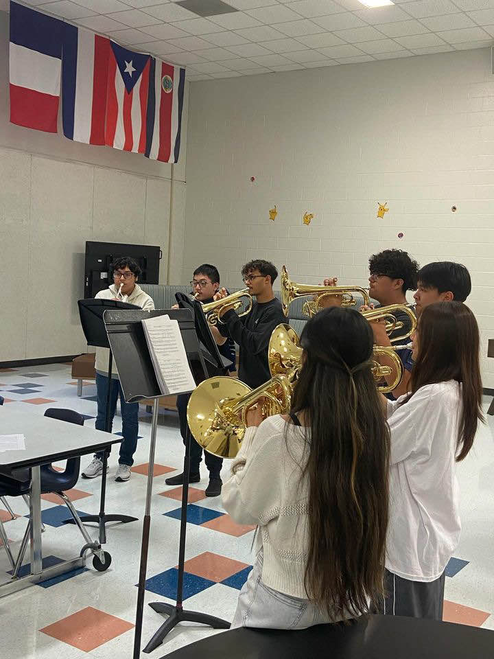 Mellophones in Motion: Band members practice their music in the cafeteria, They read and practiced their notes in unison. "It’s a little unusual practicing here, but we make it work and keep pushing forward," Raiyyan Khan said.
