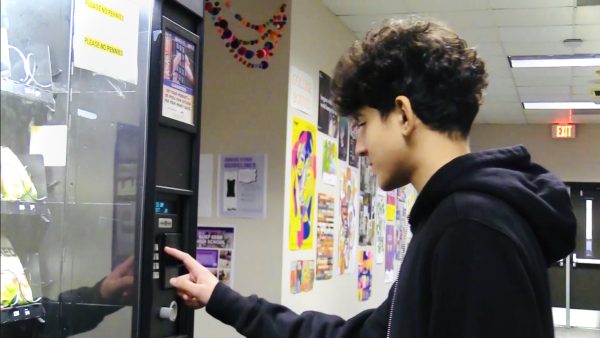 Aazan Nawaz buys a snack from vending machine.