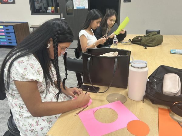 Crafting Dots! Tania Molina, Ashley Chavez Carrillo, and Sharon Piedrasanta cut out colorful dots and write one word on it. Molina went with the color pink and wrote "believe" on it to incorporate dreaming big in a sense. "I absolutely adore this club and I'm sad to leave it as I am graduating early," Molina said. 