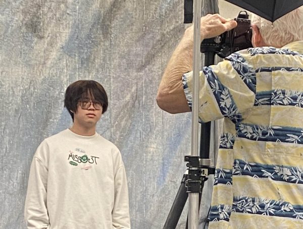 Smile For The Pciture! Junior Tuan Cao poses infront  of the camera for his yearbook photo. He arrived to the room during first period and was directly quickly towards the photographers. "I did not know it was picture day today, it was unexpected," Cao said