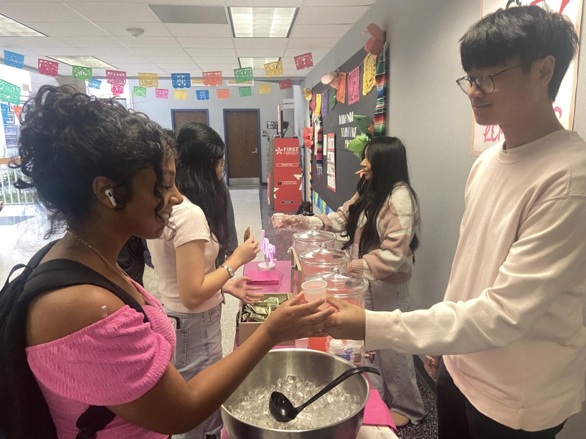 Pink lemonade! Aidan Le gives pink lemonade to Ava Drummond during lunch. The lemonade stand was free of charge to all students but donations were strongly encouraged. "It's a fun way to raise money for an important cause, I donated three dollars," Drummond said. 