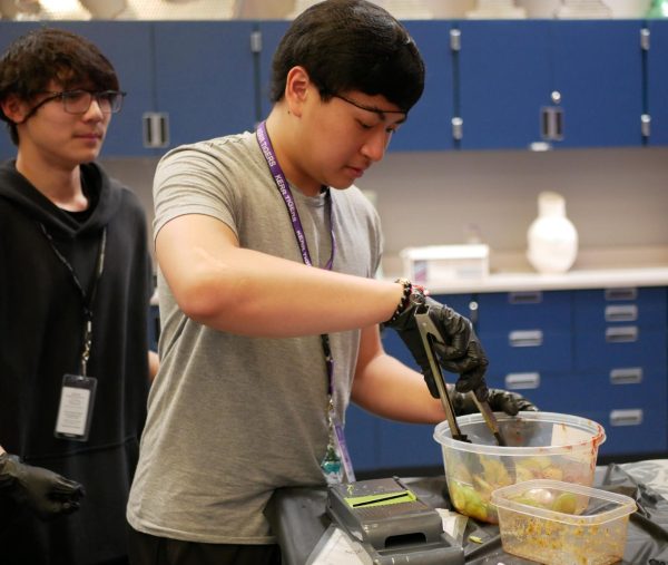 Time to Cook! An Tran watches as Bach Tran stirs the cucumber salad. They let it marinate for 20 minutes before eating. "It's so good," B. Tran said.