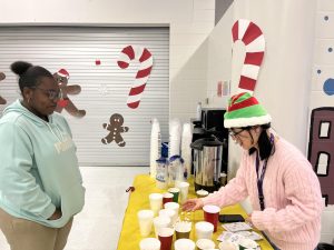 Feeling festive. Shirley Doan prepares hot cocoa for Anthonia Rafua. They were spotted at the cozy hot cocoa booth as Rafua patiently awaiting her drink. "What a wonderful way to wrap up the year with a winter social," Doan said. 