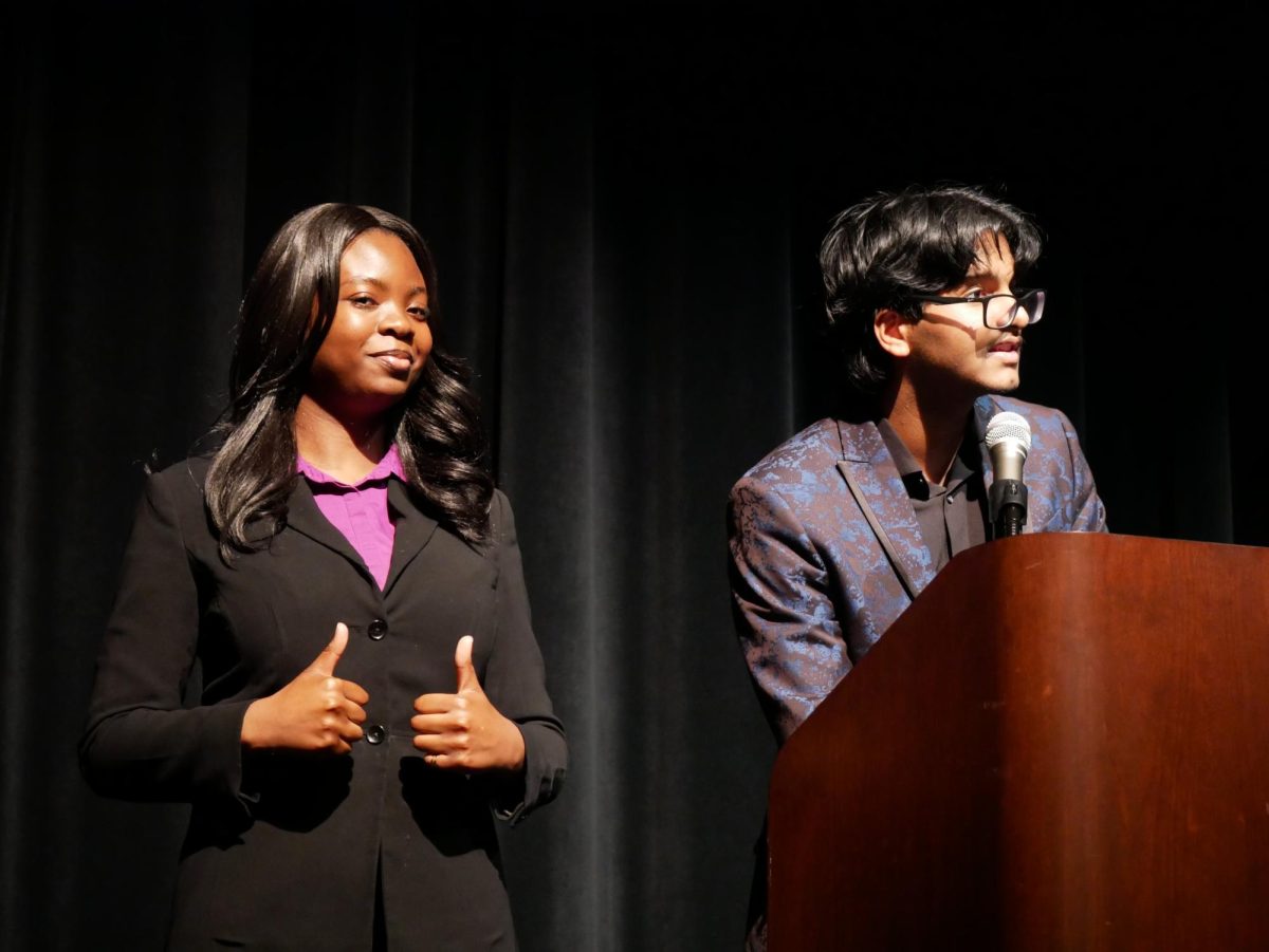 A Wonderful Speech: NHS officers Rebecca Oyeniyi and Muhammad Annas speak at the induction ceremony. They waited to start calling names and pass out the candles. "It went by really fast," Oyeniyi said.