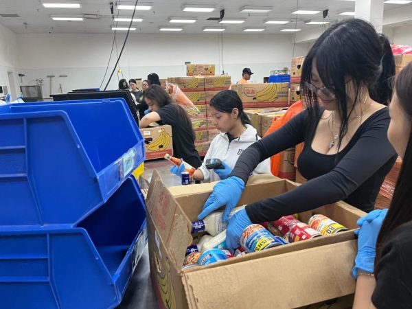 Hard At Work: Ashley Chavez and Katelyn Tieu sort through donated boxes. They scanned the donated goods to see if they were okay to keep, trash, or put in different categories. "It was a lot of work," Tieu said.