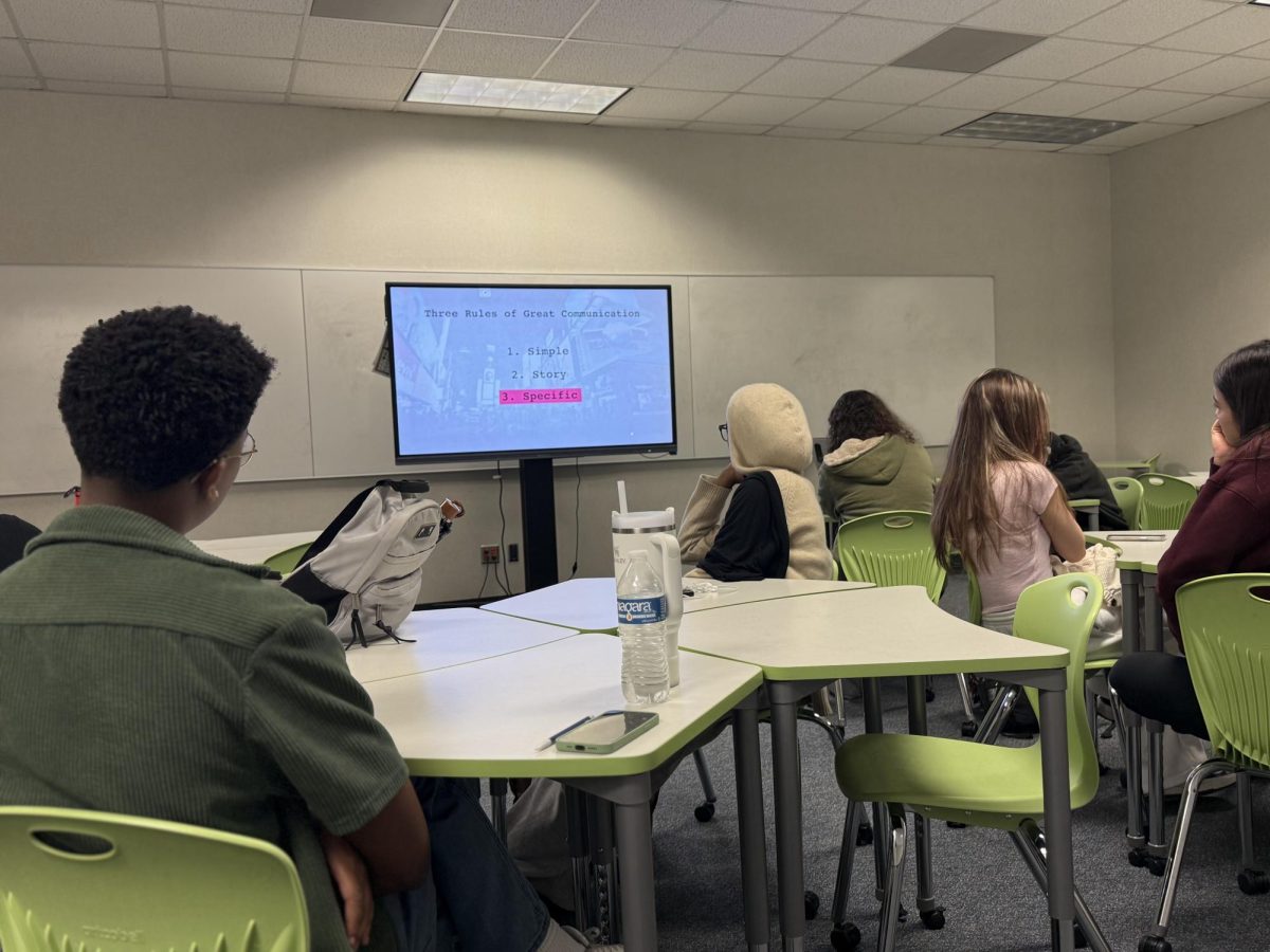 Mastering Communication: Freshman Parker Hansbrough listens to a presentation on effective communication. He uses these skills while writing the mini-grant. "I really hope we win the grant," Hansbrough said. 