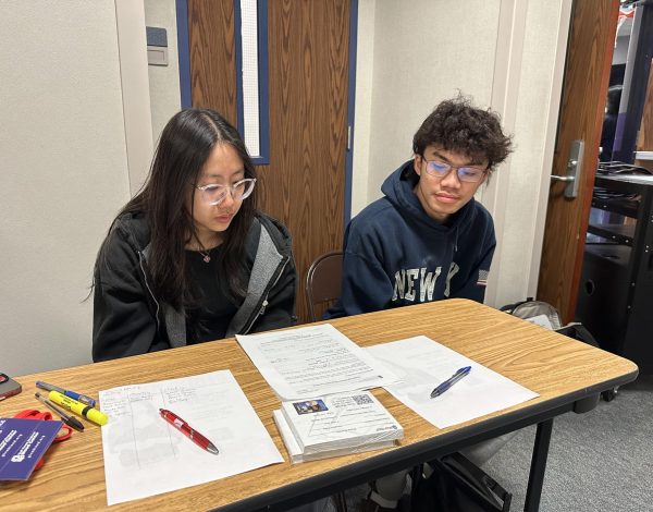 Keeping Things in Check: Volunteers Nhi Le and Phat Luong sit outside of the gym. They make sure that donors sign in and fill out the questionnaire beforing entering. "It was fun volunteering," Le said.