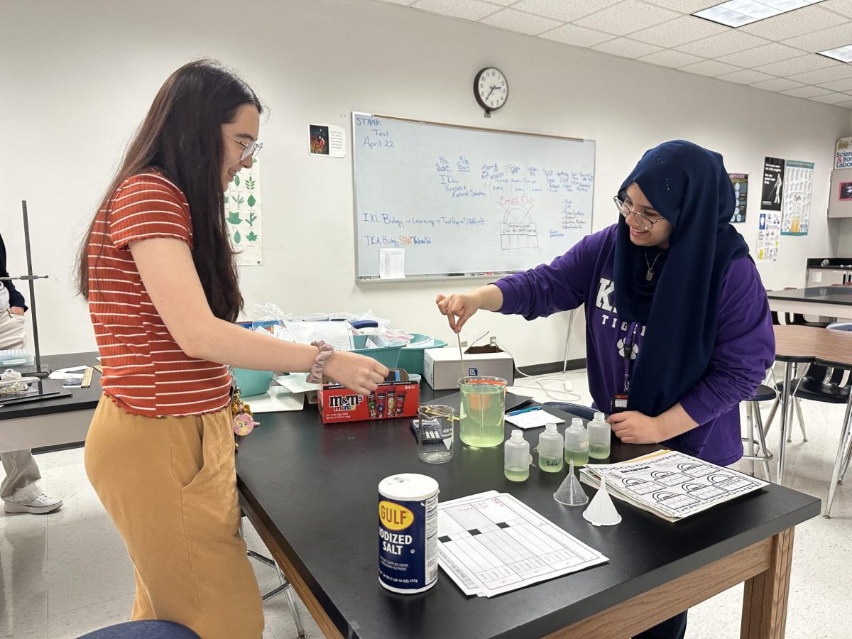 Staying Prepared: Officers Iris Hoang-Dugan and Manar Al-Gburi prepares the buffer solution for the experiment. They poured in salt into the solution with a mixture of soap and water. "It was easy to prepare," Al-Gburi said.