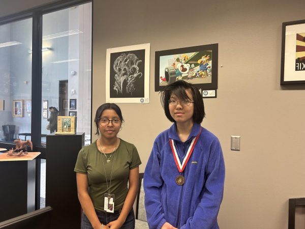 Picture Perfect! Ashley Chavez Carrillo and Jennifer Wong pose proudly in front of their state-awarded artwork. Now on display in the front office lobby for everyone to admire. “I am so happy about my art piece,” Carrillo said.