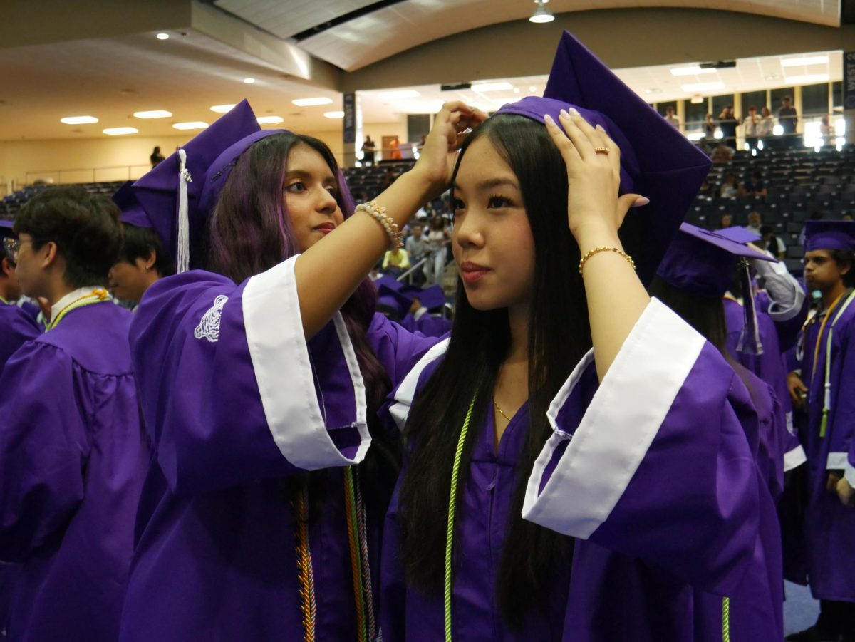 Alisha Rahman adjusts the cap for Christina Trieu before graduation starts.