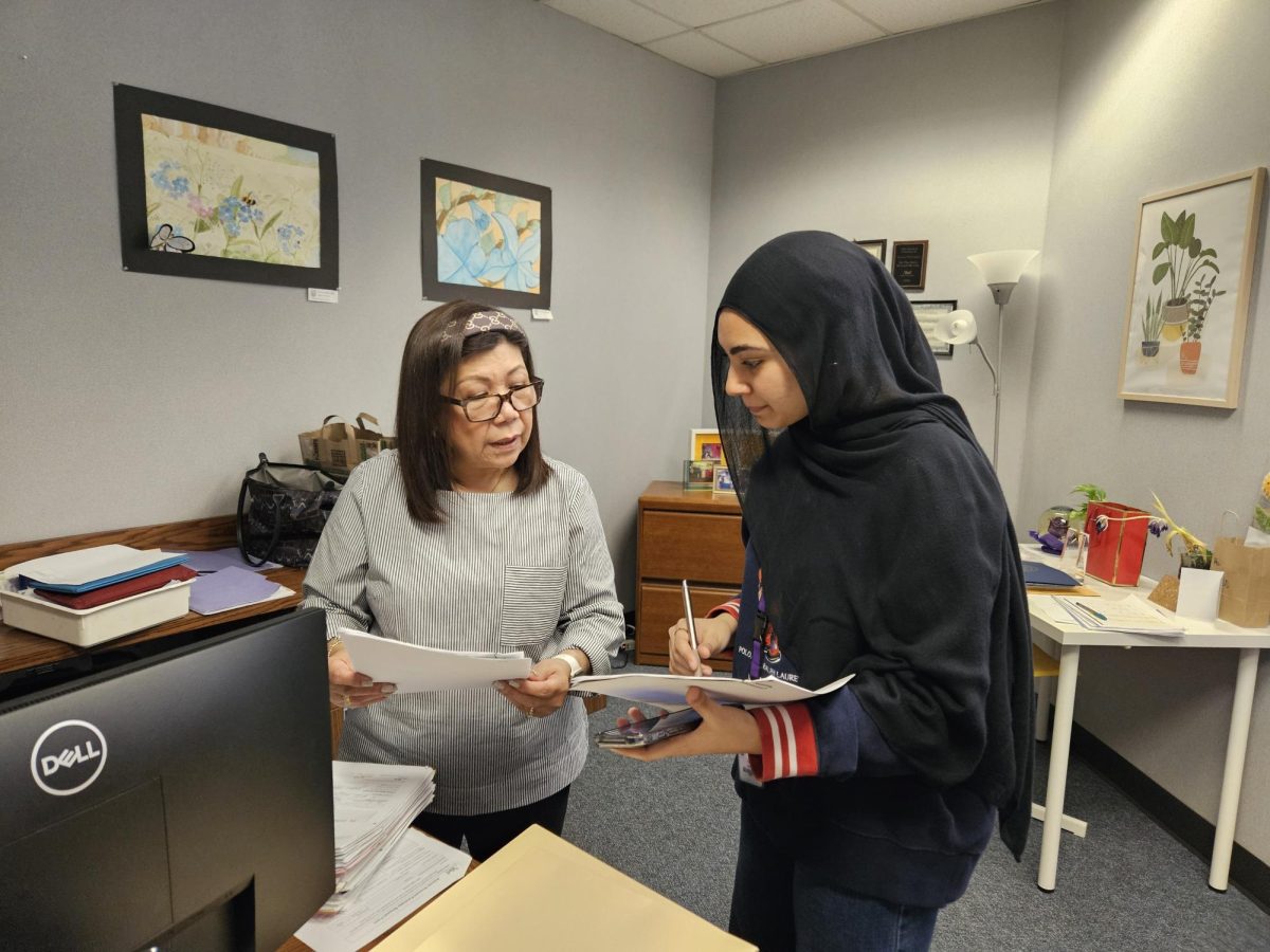Marites Mabilangan helps MSA President Iqra Naveed with club finances.