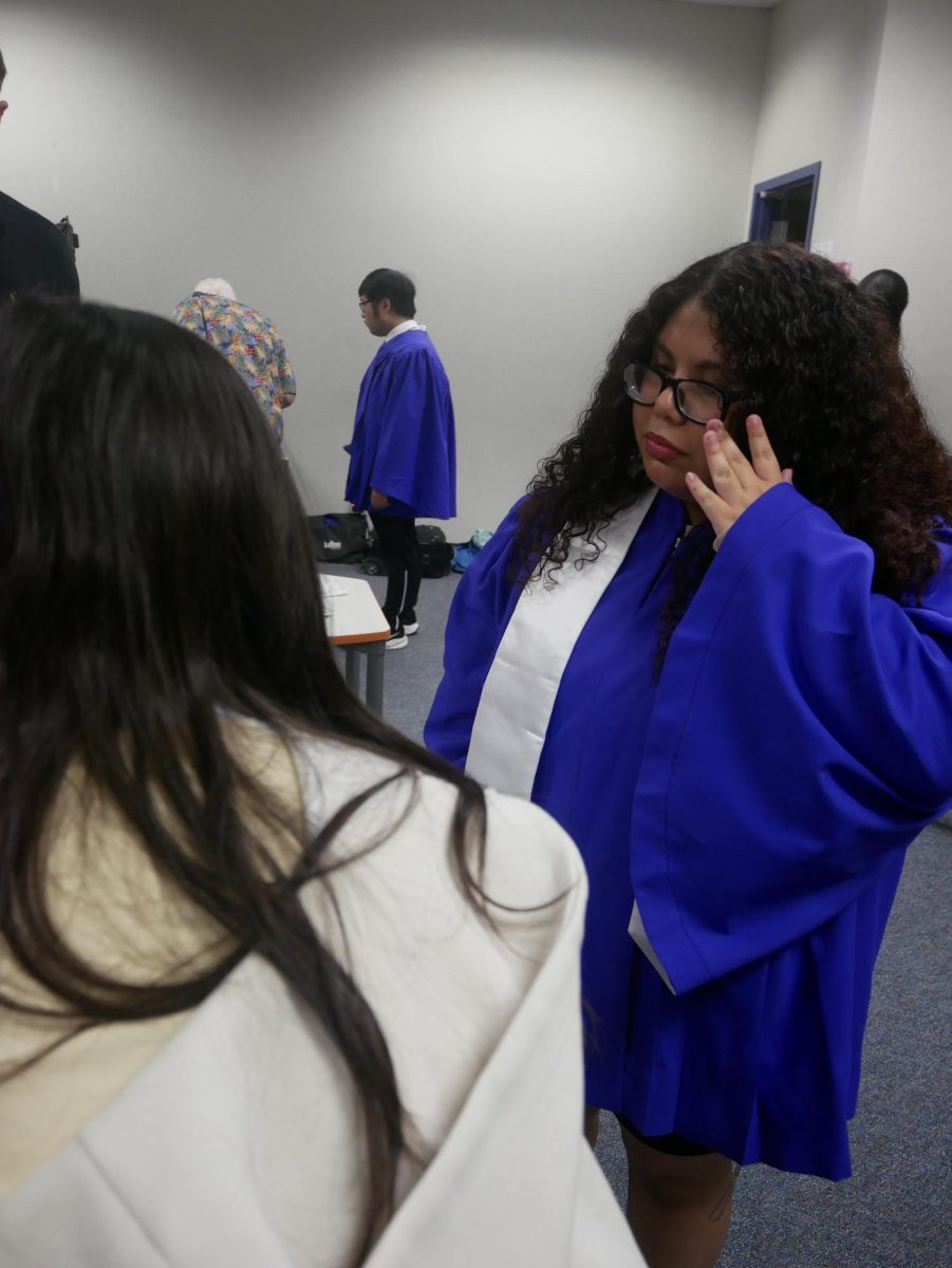 Seniors Head On In. Alison Ramos¹² waits for her turn to be photographed by photographer Jeff Grass. After a long wait, she finally made it to room 333 for her picture. "It was pretty surreal because I wasn't sure what to expect or whether I should smile. I had originally planned not to smile since I usually look awkward, but after finishing the photos, I ended up liking the ones where I smiled the most," Ramos said.