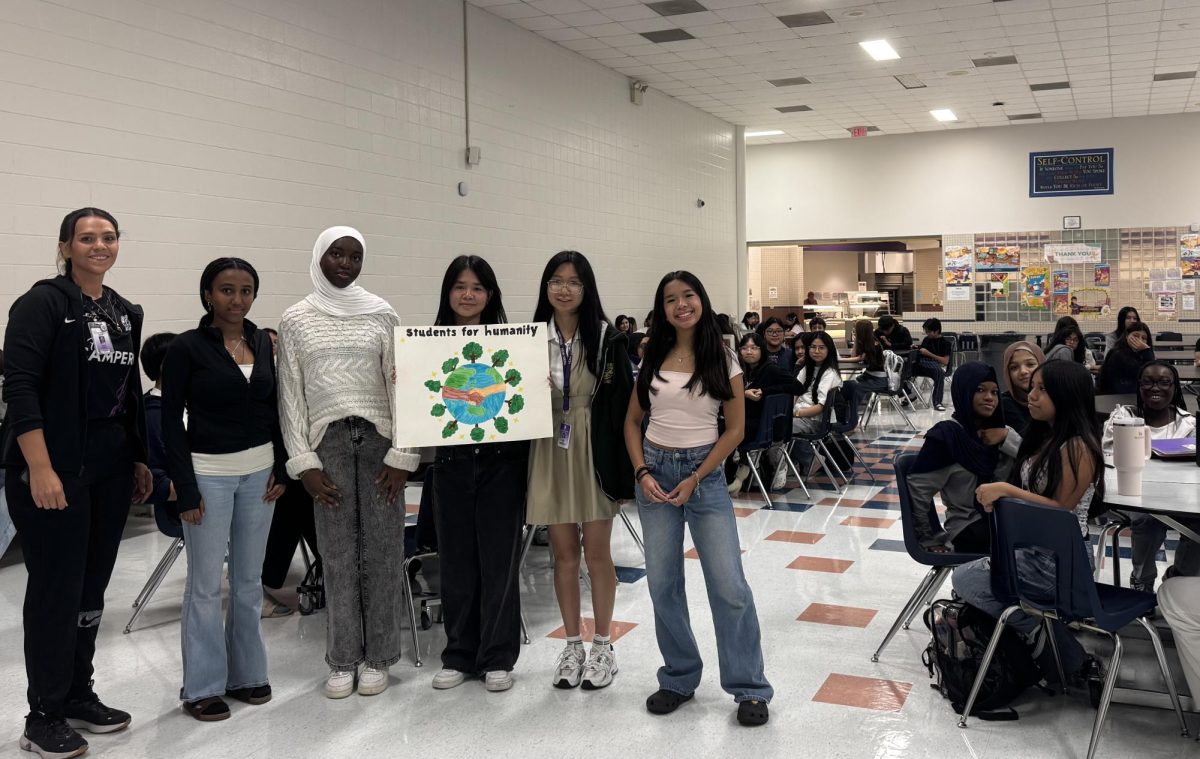 The Beginning: Students for Humanity officers, senior Jenney Luong, senior Michella Dao, sophomore Mariam Alimi, sophomore Katelyn Nguyen, Junior Aresema Hagos, and sponsor Karen Orta gather with new members in the cafeteria. The officers outline the club’s mission and planned volunteer events for the upcoming year, encouraging students to join their community efforts. “We can’t wait to see what this year has in store,” said Officer Nguyen.