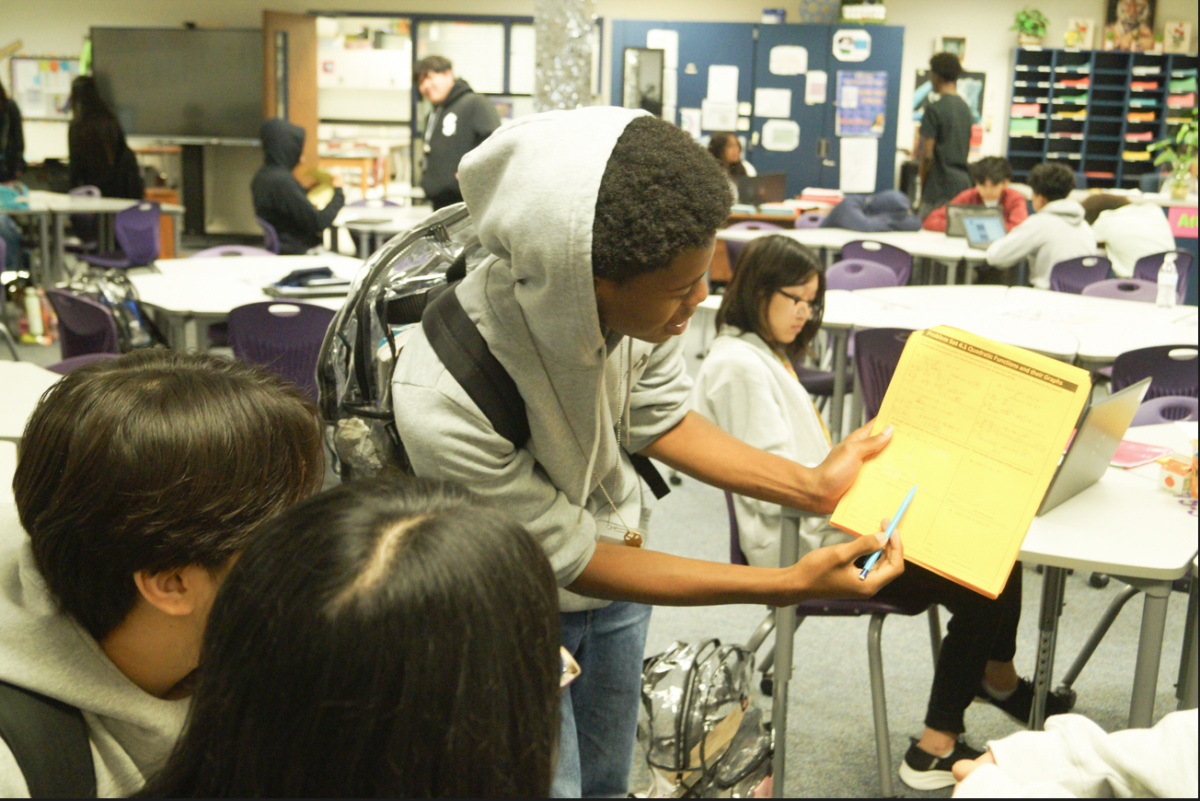 Barak Redhead (10) helps explains math prolems to Minh Vo (10) and Tran Nguyen (10) during advisory.