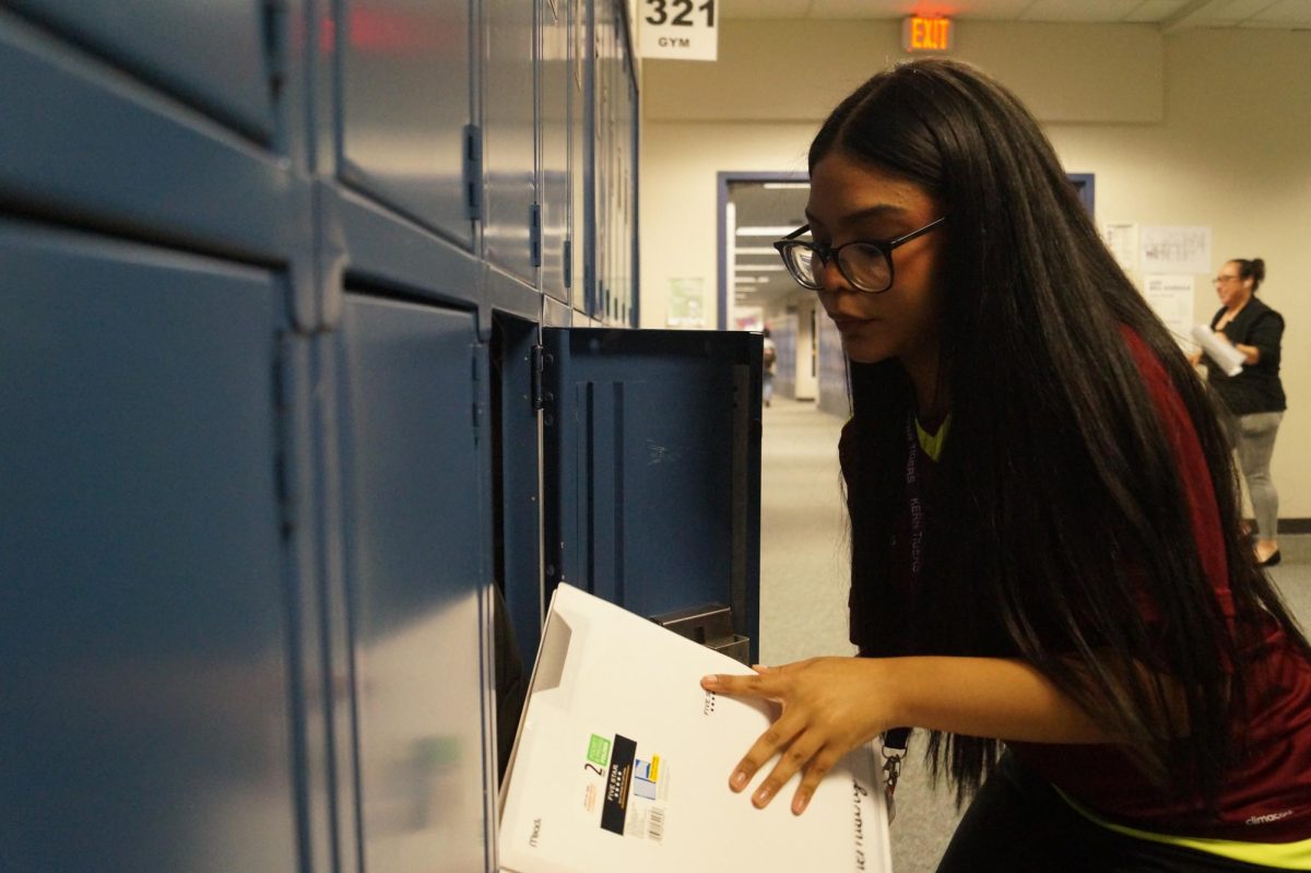 Sofia Sanchez (10) places her homework folder in her locker.